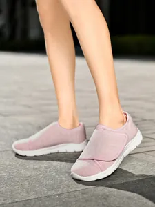 Dettaglio di scarpe da camminata in mesh traspirante rosa con chiusura a strappo.