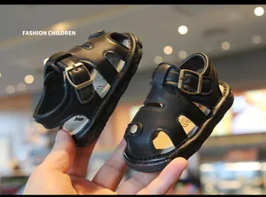 Detailed macro shot of black baby summer sandals with a non-slip soft sole and hollow design