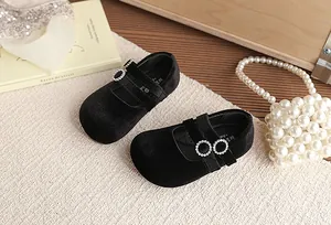 Detailansicht von Vintage Mary Jane Schuhen aus schwarzem Samt mit glänzenden Schnallen.