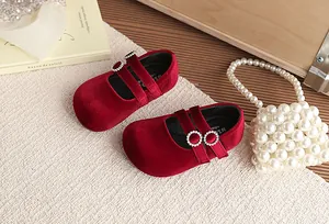 Detailansicht der roten Samt-Mary-Jane-Schuhe für Mädchen mit funkelnden Strass-Schnallen