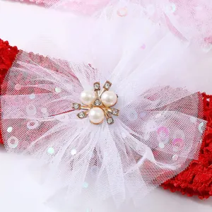 Primer plano detallado de diadema para bebé con lazo de malla blanca y adorno de perlas.
