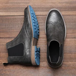 Nahaufnahme der klassischen Brogue Chelsea-Boots für Herren mit blauer Profilsohle.