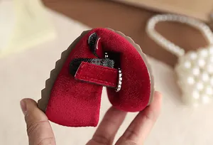 Nahaufnahme der flexiblen, weichen Sohle der roten Samt-Mary-Jane-Schuhe für Mädchen
