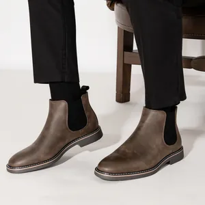 Close-up view of retro brown men's Chelsea boots with elastic side panels on feet