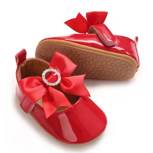 Detailansicht der roten Lackleder-Babyschuhe mit großer Schleife und Strass-Schnalle.