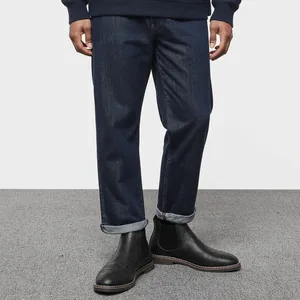 Detail view of stylish black retro Chelsea boots paired with dark denim jeans for men