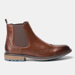 Detailansicht der braunen Brogue-Chelsea-Stiefel aus Leder mit Flügelkappenschnitzerei