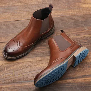 Detail von braunen Chelsea-Boots aus Leder mit Brogue-Schnitzerei und blauer Sohle