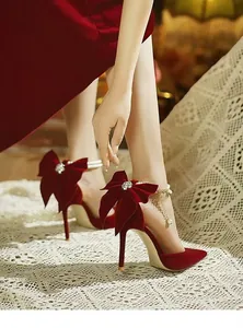 Vue détaillée d'escarpins en velours rouge avec grand nœud et bride en perles