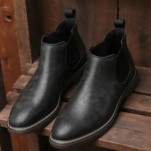 Close-up of black retro men's Chelsea boots with elegant stitching on wooden background