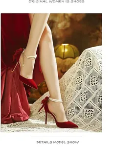 Modèle portant des talons aiguilles en velours rouge avec perles et nœud