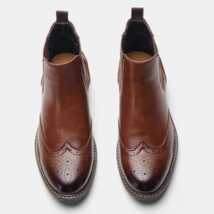 Detaillierte Draufsicht auf braune Chelsea-Boots für Herren mit klassischen Brogue-Verzierungen