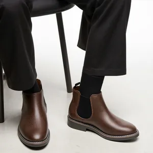 Close-up of brown pebbled leather Chelsea boots with black elastic side panels.