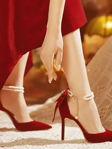 Talons hauts en velours rouge élégants avec bride perle et nœud au talon.