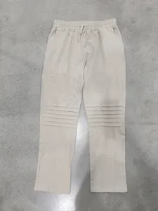 Detail of men's loose linen pants featuring horizontal pleated leg design