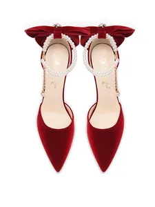 Vue détaillée de talons aiguilles en velours rouge avec perles et nœuds décoratifs