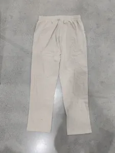 Detailed back view of men's loose linen straight-leg trousers in a minimalist beige style