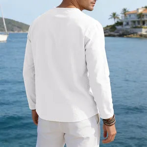 Back view of a loose white linen long sleeve T-shirt for men in a seaside setting