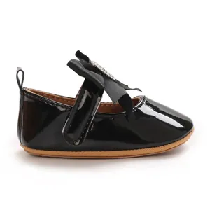 Side view of black patent leather baby walker shoes with a sparkling rhinestone bow detail