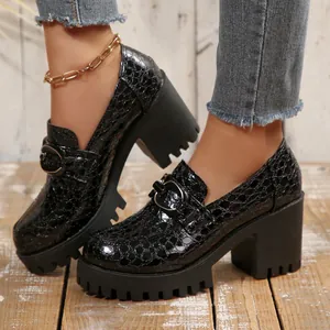Detail van zwarte dames loafers met krokodillenprint en stevige plateauzool.