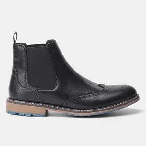 Seitenansicht schwarzer Brogue Chelsea Boots mit dekorativen Lochverzierungen.