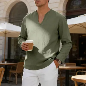 Lifestyle view of a man in a sage green linen V-neck shirt at an outdoor cafe.