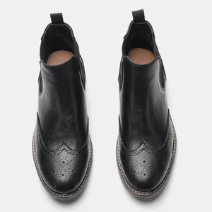 Detaillierte Draufsicht auf schwarze Brogue Chelsea Boots mit feinen Lochverzierungen.