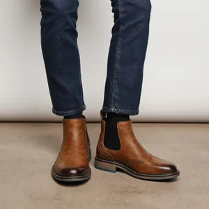 Nahaufnahme der braunen Brogue-Chelsea-Boots für Herren mit dekorativen Lochungen.