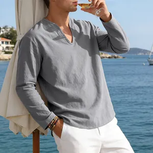 Detail view of a men's loose gray linen V-neck long sleeve shirt in a beach setting.