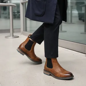 Detailansicht stilvoller brauner Chelsea-Boots mit Budapester Muster zu dunkelblauer Hose