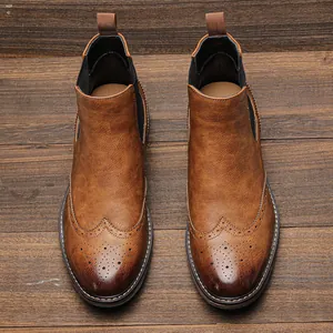 Draufsicht auf braune Brogue-Chelsea-Boots im Vintage-Look auf rustikalem Holzuntergrund.