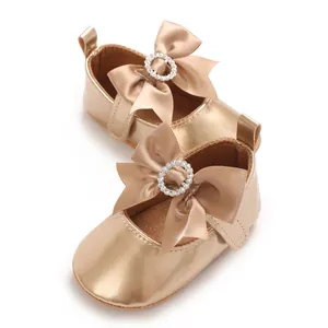 Detailed view of champagne gold baby walking shoes with bow and rhinestone buckle