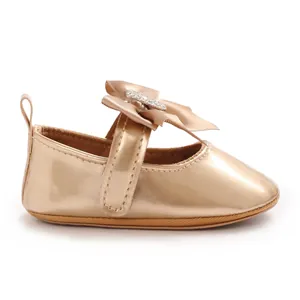Detailansicht der glänzenden champagnegoldenen Baby-Mary-Jane-Schuhe mit großer Schleife