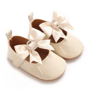 Elegant beige baby Mary Jane shoes with ribbon bow and sparkling crystal ring detail.