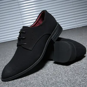 Close-up of black suede men's derby shoes with elegant lace-up detail and red lining