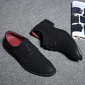Side view of men's matte black lace-up oxford shoes with red lining on grey carpet.