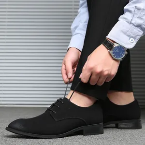 Close-up of black suede lace-up dress shoes worn with professional business attire