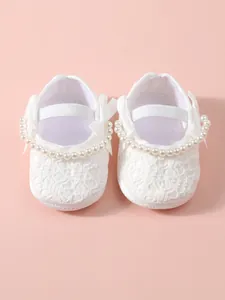 Elegante weiße Baby-Prinzessin-Schuhe aus Spitze mit Perlenband und einer kleinen Schleife