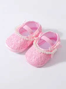 Detaillierte Ansicht rosa Baby-Prinzessin-Schuhe aus Spitze mit Perlen und Satinschleife