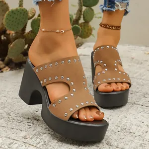 Gros plan de sandales à plateforme en daim marron avec rivets et talons épais