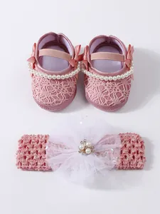 Detail of pink lace baby princess shoes and matching floral headband set with pearls