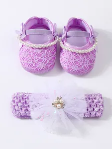Close-up of purple baby lace shoes and matching floral headband set with pearls