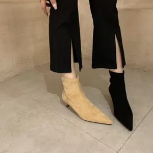 Nahaufnahme von spitzen Stiefeletten mit Pfennigabsatz in Beige und Schwarz aus Wildleder