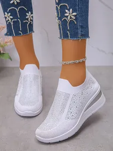 Nahaufnahme der weißen Fly-Knit-Keilsneaker mit funkelnden Strassstein-Details