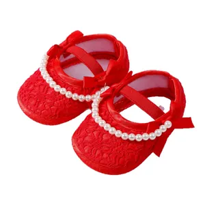 Rote Lauflernschuhe für Mädchen mit Perlenbesatz und Seidenschleifen-Dekorationen.