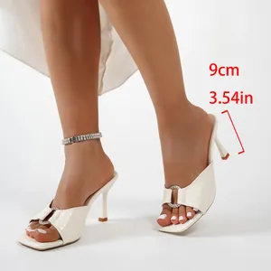Détail du talon de 9 cm sur une mule blanche à bout carré avec un motif gaufré crocodile.
