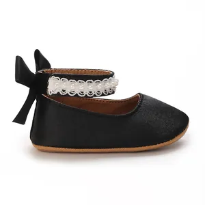 Detailed view of black baby girl princess shoe featuring pearl lace and bow detail