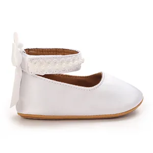Elegant white baby girl princess shoes featuring pearl ankle strap and silk bow detail