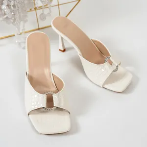 Mules blanches à bout carré avec effet crocodile et boucles décoratives en strass