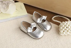 Close-up of silver bow girls' princess shoes with metallic finish and soft sole detail